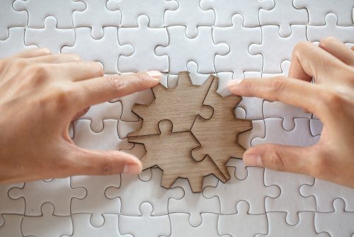 Close up of hands business women connecting jigsaw puzzleon, Business Success,  Teamwork workplace success and strategy concept.