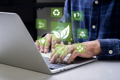 Businessman analyzes sustainable investment with environmental icons On the computer screen, concepts of setting goals for a sustainable environment such as ESG, Net Zero, carbon credits, taxes, etc.